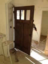 Front door being painted with sprayer by workman - view from inside of door