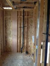 Standing in opening of laundry room looking at plumbing and