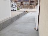 New concrete drive pad and verticle concrete wall to right of house