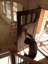 Front door being painted with sprayer by workman 2