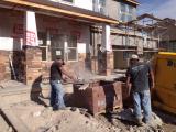 Stone being cut by workman, lots of dust